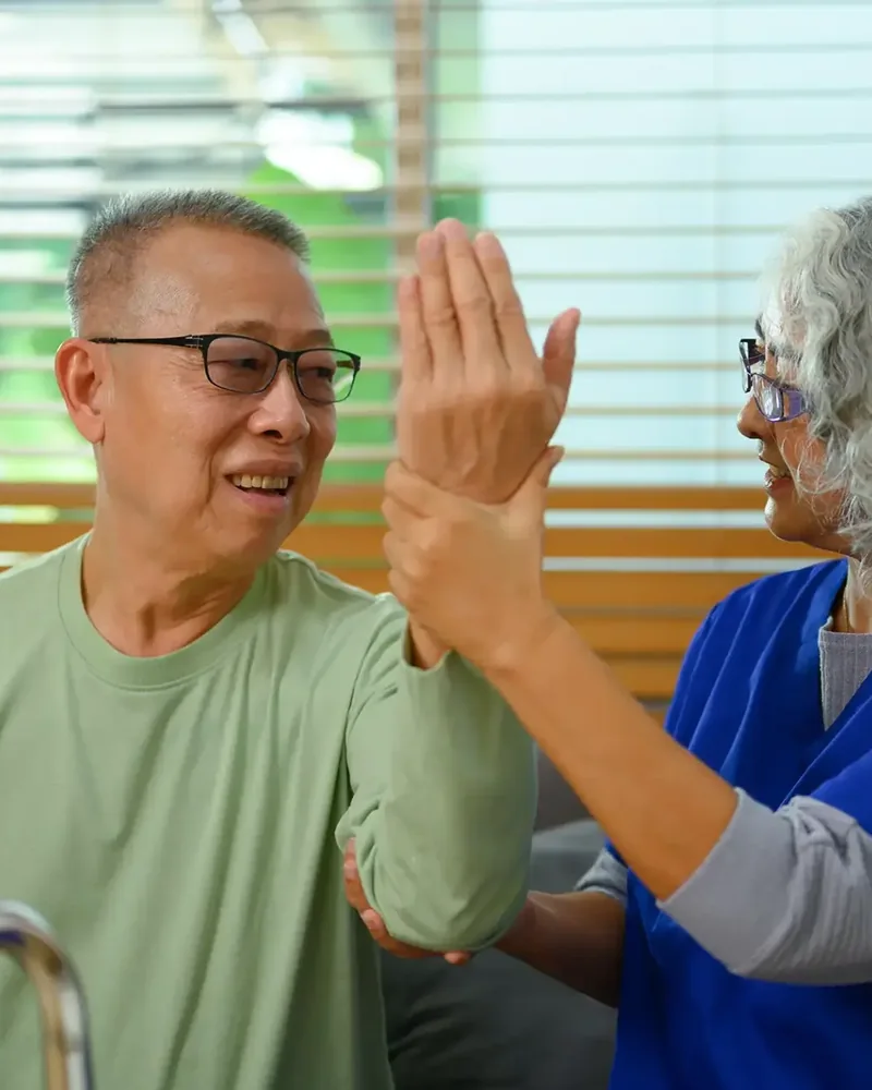 Therapist coaching a patient with Parkinson's through large amplitude movement exercises