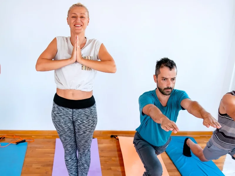 Therapist supporting a patient walking between parallel bars