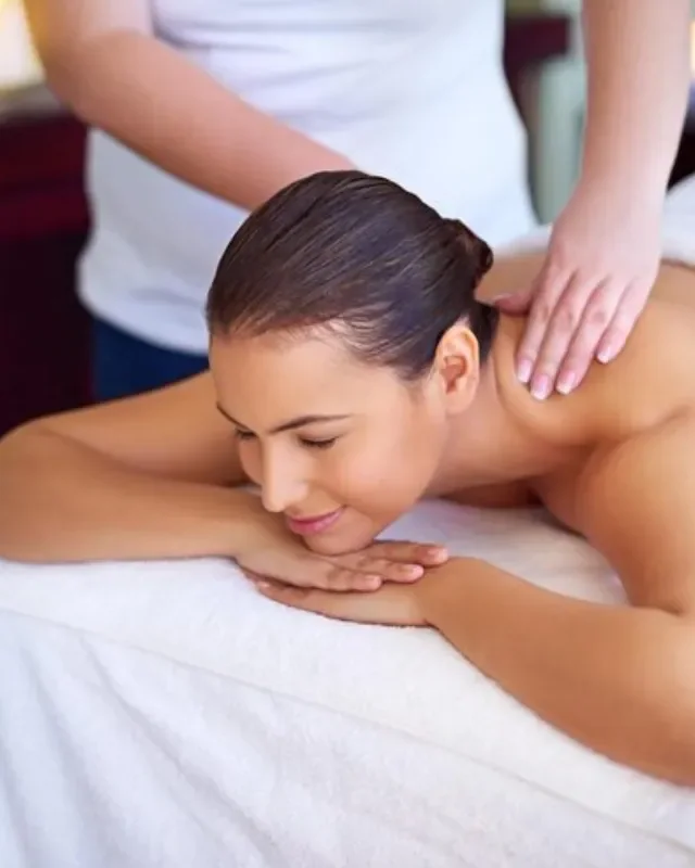Therapist applying deep tissue massage to a patient's shoulder