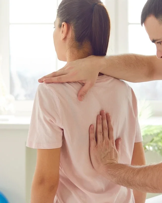Licensed physical therapist performing spinal manipulation on a patient's mid back